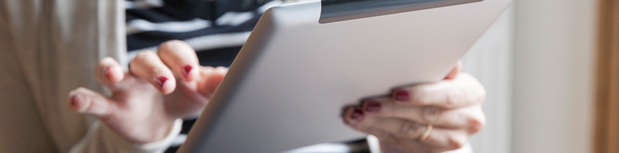 Frau hält ein Tablet und liest