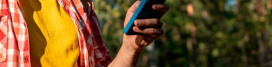 Mann mit Smartphone beim Wandern