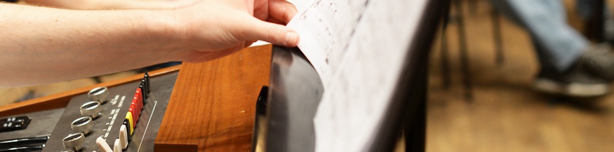 Hand greift nach Notenblatt