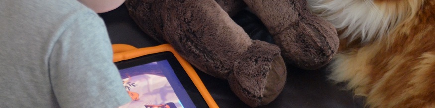 Kind mit iPad, Teddybär und Katze