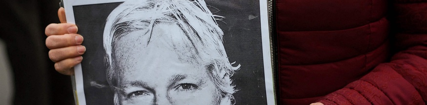 Julian-Assange-Plakat in Händen einer Frau