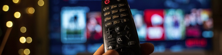 Popcorn, Fernbedienung und Netflix im Hintergrund