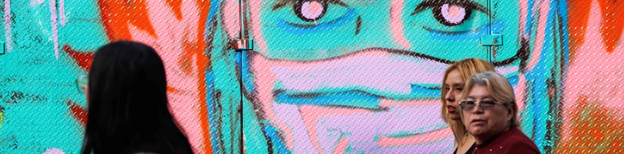 Frauen in Mexiko vor einem Grafitti