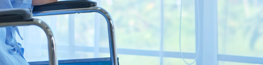 Dame in einem Rollstuhl in einem Krankenhaus am Fenster