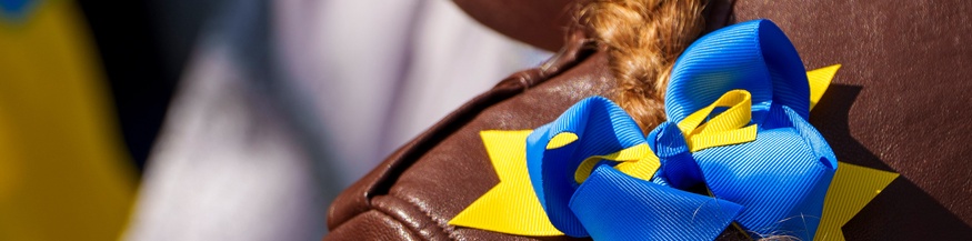 Junges Mädchen mit Zopf und Masche in den Farben der Ukraine