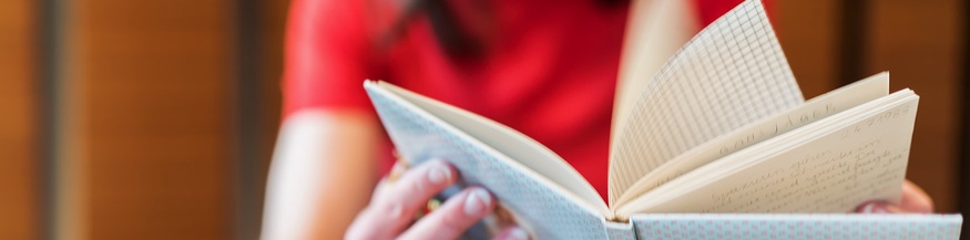Frau blättert im Tagebuch
