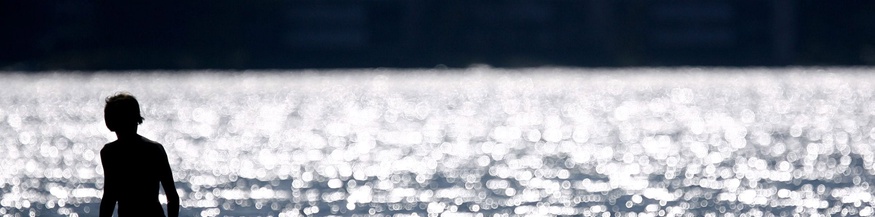 Eine Person im Wasser am Strand in Finnland