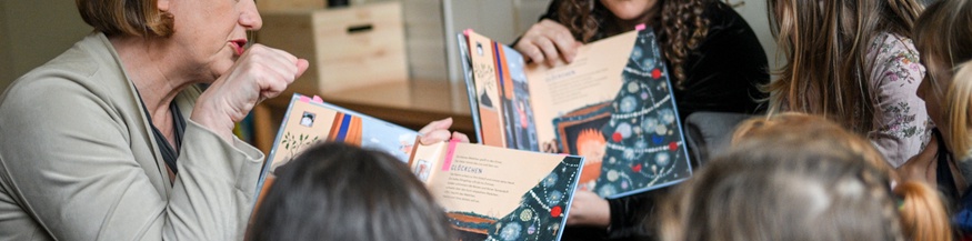 Zwei Frauen lesen Kindern vor