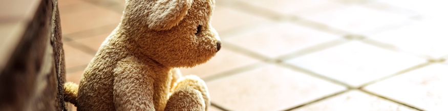 Kleiner Teddybär bei gefliesten Stufen