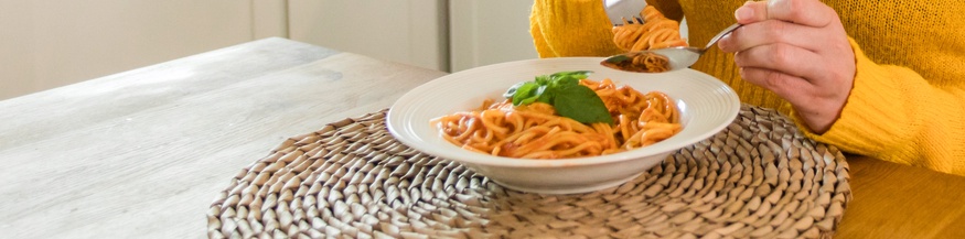 Eine Frau isst einen Teller Spaghetti