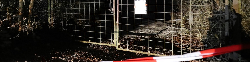 Polizeiabsperrband im Dunkeln, Gittertor