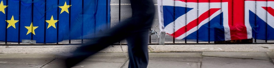 Passant vor EU- und UK-Fahnen