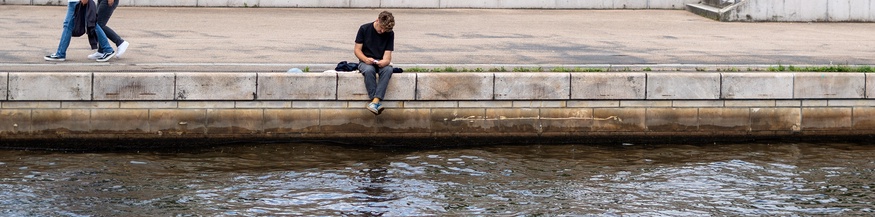 Lesender Mensch an der Spree in Berlin