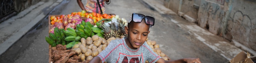 Alltag in Kuba: Kind mit Frau transportieren Gemüse