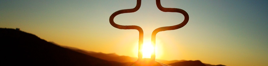 Die Sonne scheint durch in Gipfelkreuz