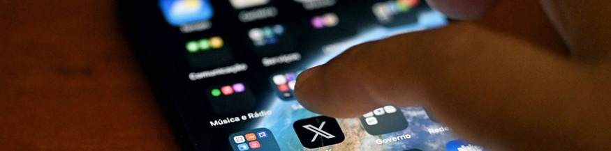 Männerhand über einem Smartphone-Display: Social-Media-Plattform X