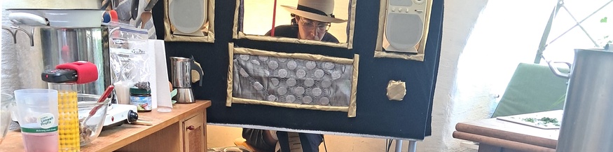 Eine Frau sitzt in einem selbstgebauten Theater-radio.