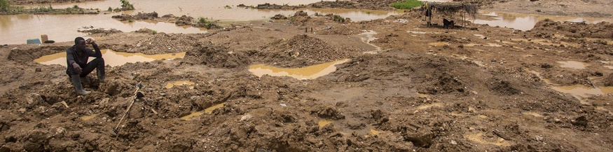Illegaler Goldabbau in Ghana, Mann sitzt im Schlamm
