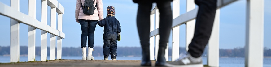 Frau und Kind stehen mit dem Rücken zum Blickwinkel