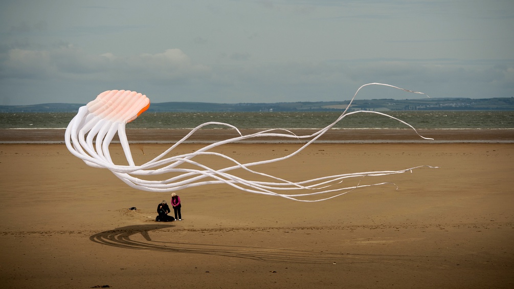 Paar lässt am Strand einen Drachen steigen