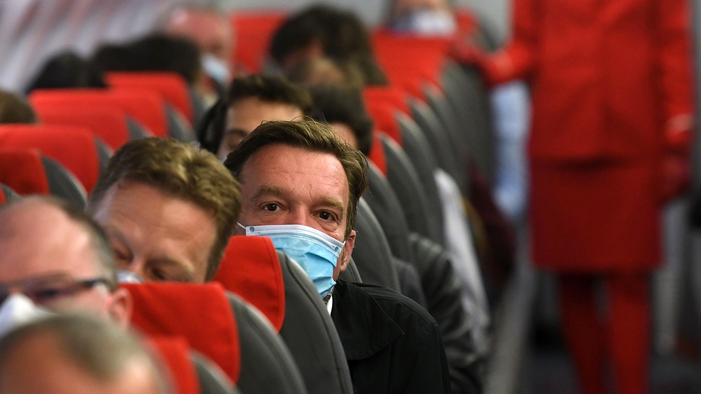 Fluggast im Flugzeug mit Maske