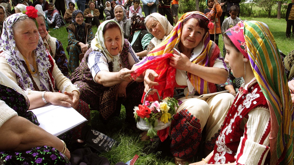 Alevitische Frauen sitzen auf einer Wiese