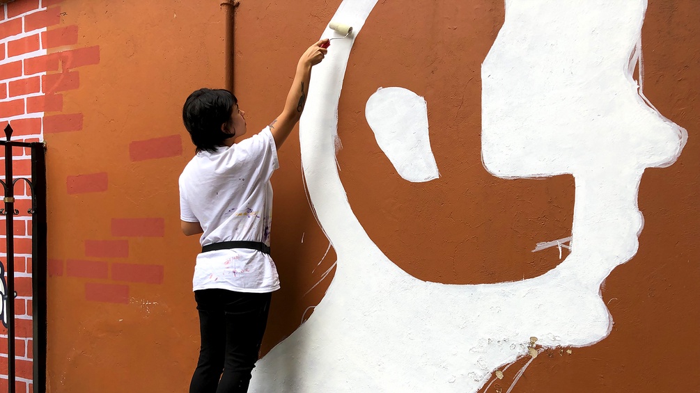 Eine Frau beim Anfertigen eines Graffitis