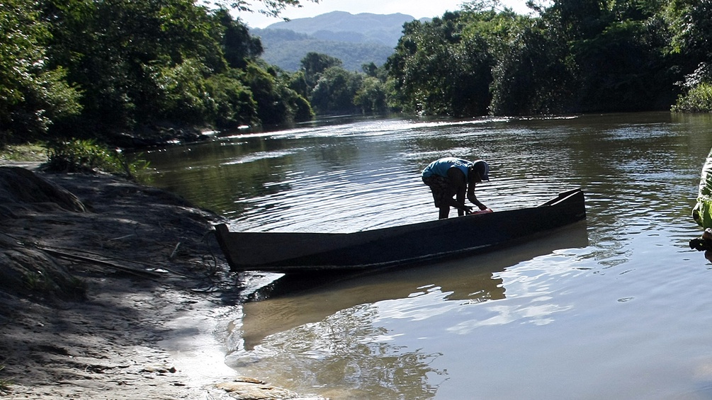 Ein Mann mit einem Boot am Ufer eines brasilianischen Flusses.