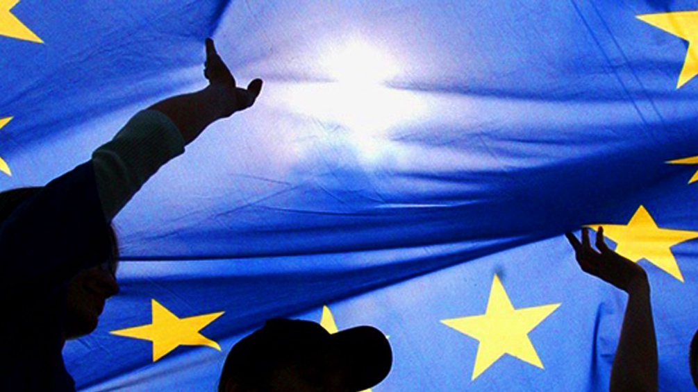 Menschen halten eine EU-Flagge in die Luft.