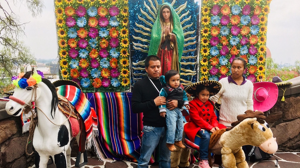 Familie in Mexiko vor Marienstatue