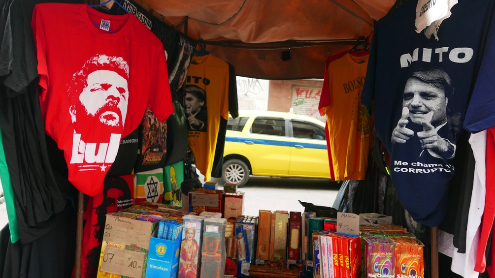 Zwei Tshirts mit dem Ex-Präsident und dem neuen Präsident hängen zum Verkauf auf einem Straßenstand in Brasilien