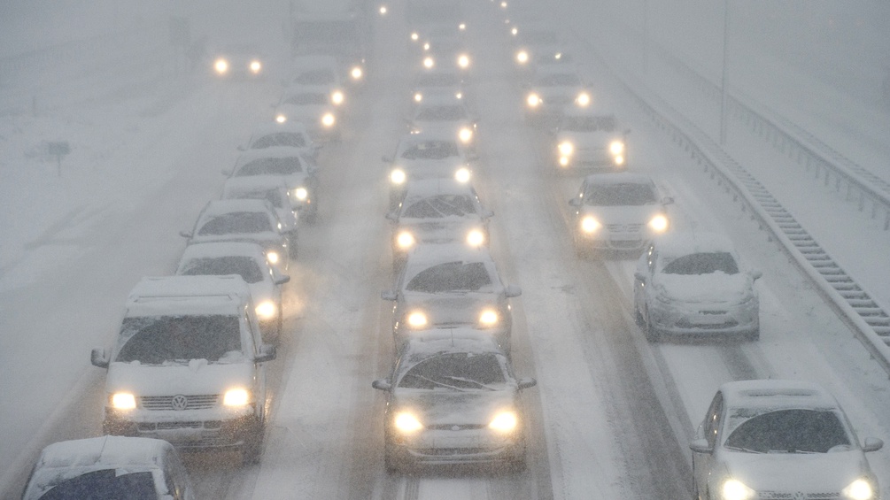 AFP/ANP/MARCO DE SWART Autos stehen im Stau auf der Autobahn und sind voller Schnee