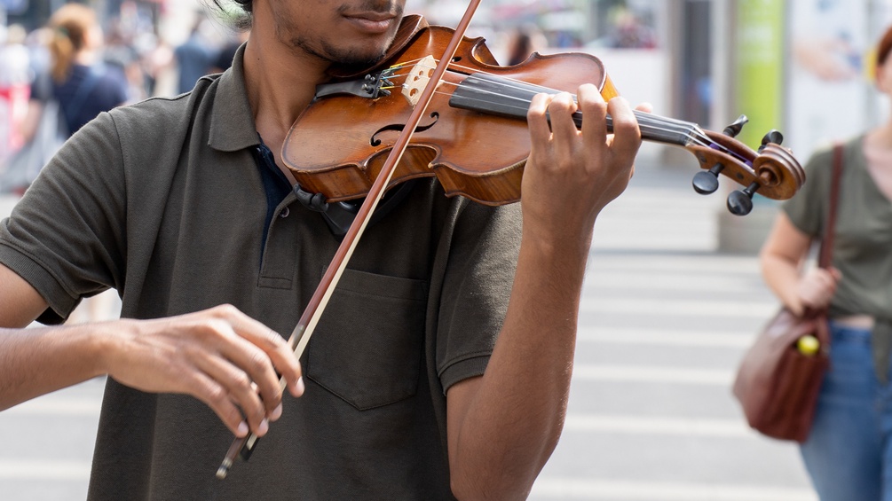 Straßenmusikant mit einer Geige spielt in Wien