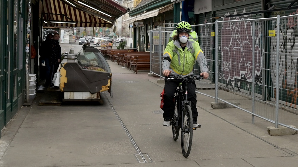Mann mit Schutzmaske auf dem Fahrrad