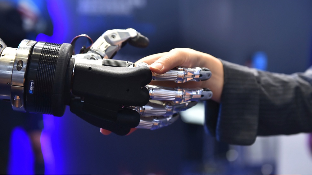 Roboter Hand schüttelt Menschenhand