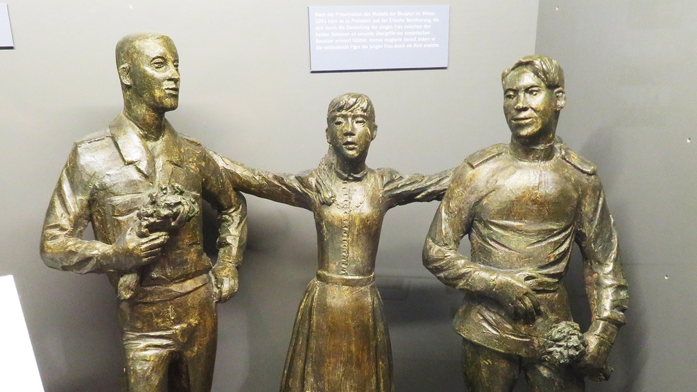 Eine Figur von zwei Männern und einer Frau in der Mitte.
