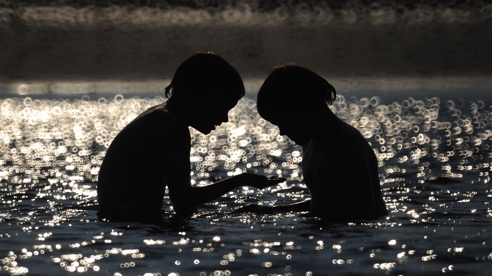 Silhouette zweier Kinder im Wasser