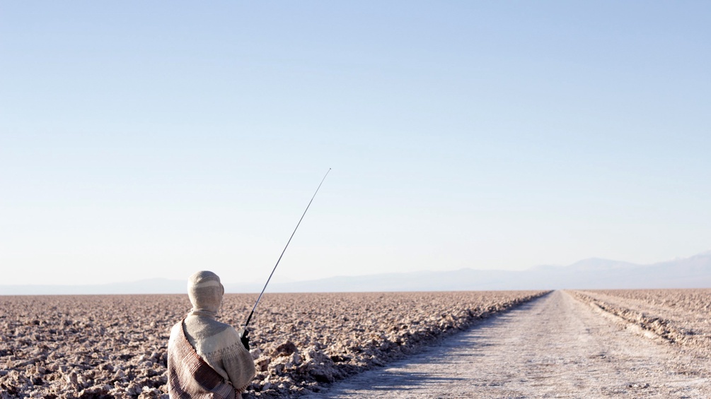 Eine Person fischt in einer Steinwüste