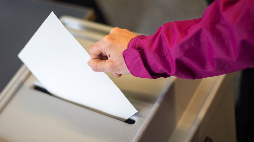 Wahlurne: Frau wirft Kuvert ein