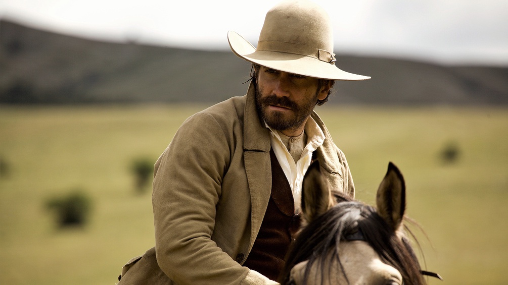 Mann mit Cowboyhut auf einem Pferd