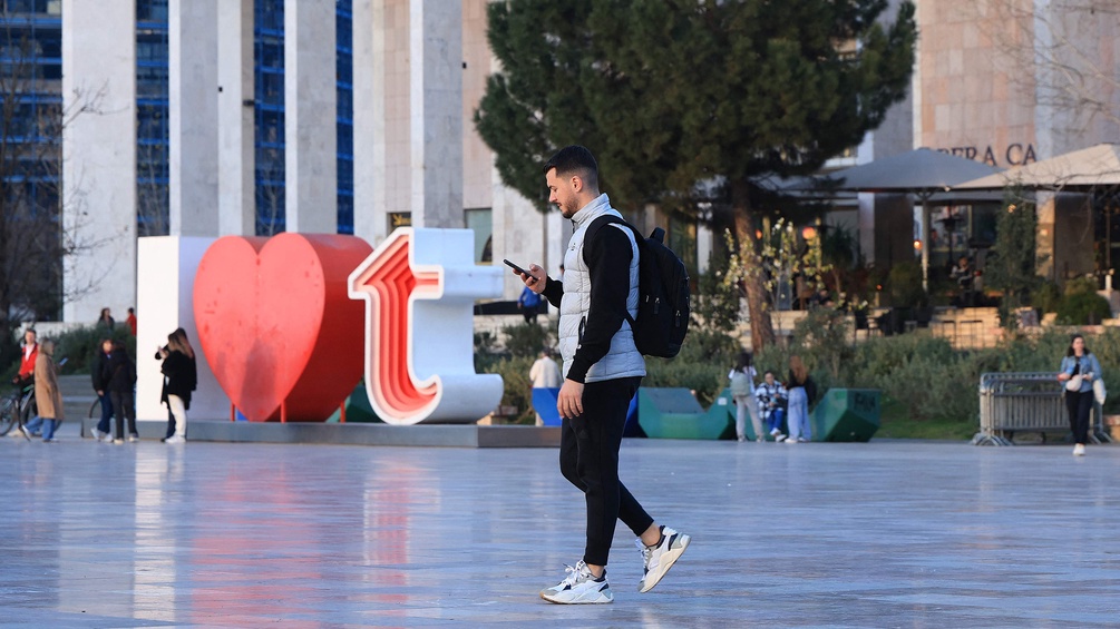 PICTUREDESK.COM/AFP/ADNAN BECI Mann mit Smartphone in Tirana, Albanien