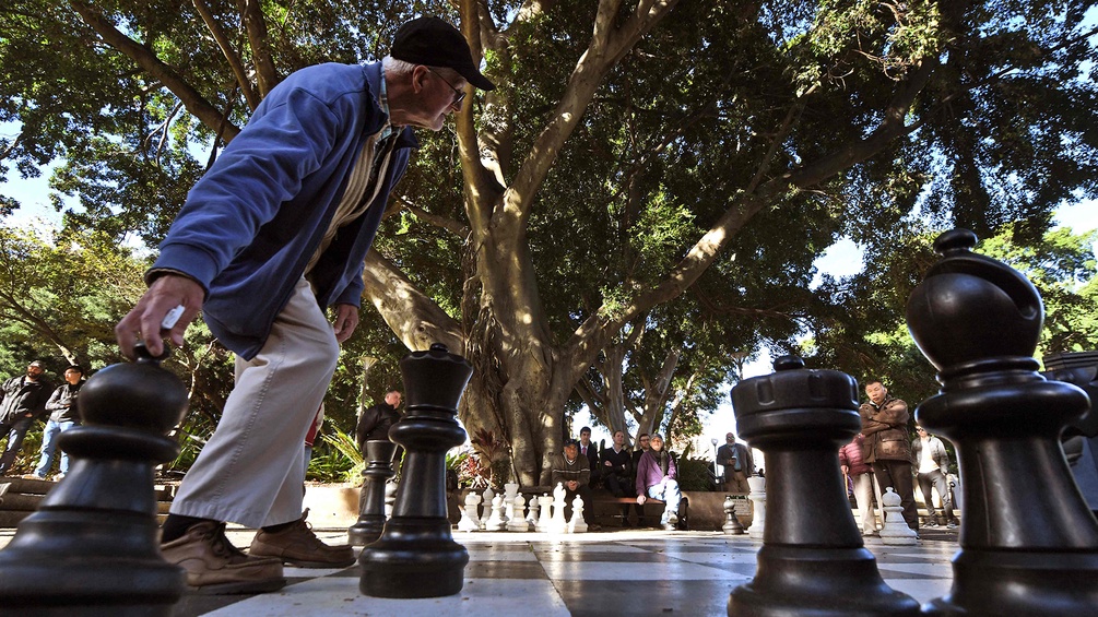 Ein Mann spielt Bodenschach im Park