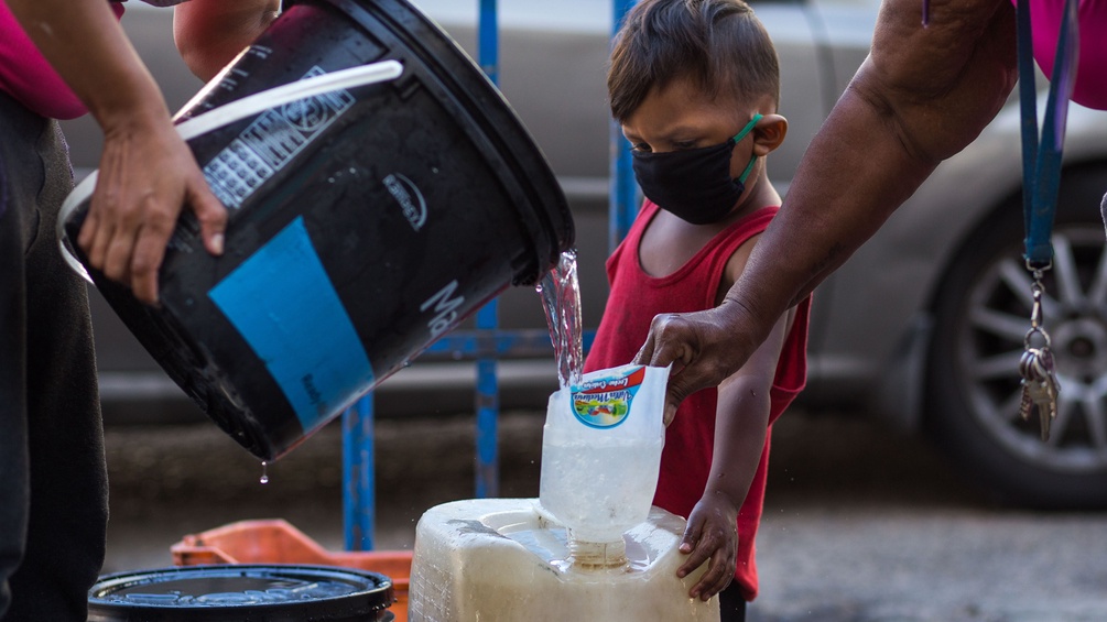 Wasser wird von einem Kübel abgefüllt in Venezuela.