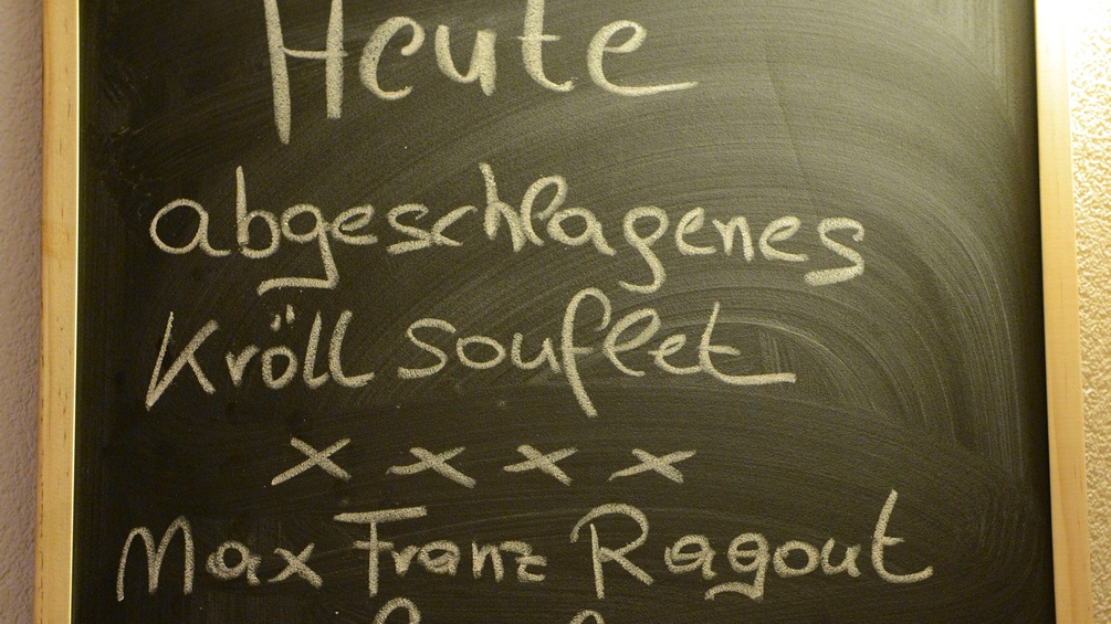 Auf einer Tafel steht in Kreide geschrieben: Heute. abgeschlagenes Kröll souflet xxxx Max Franz Ragout
