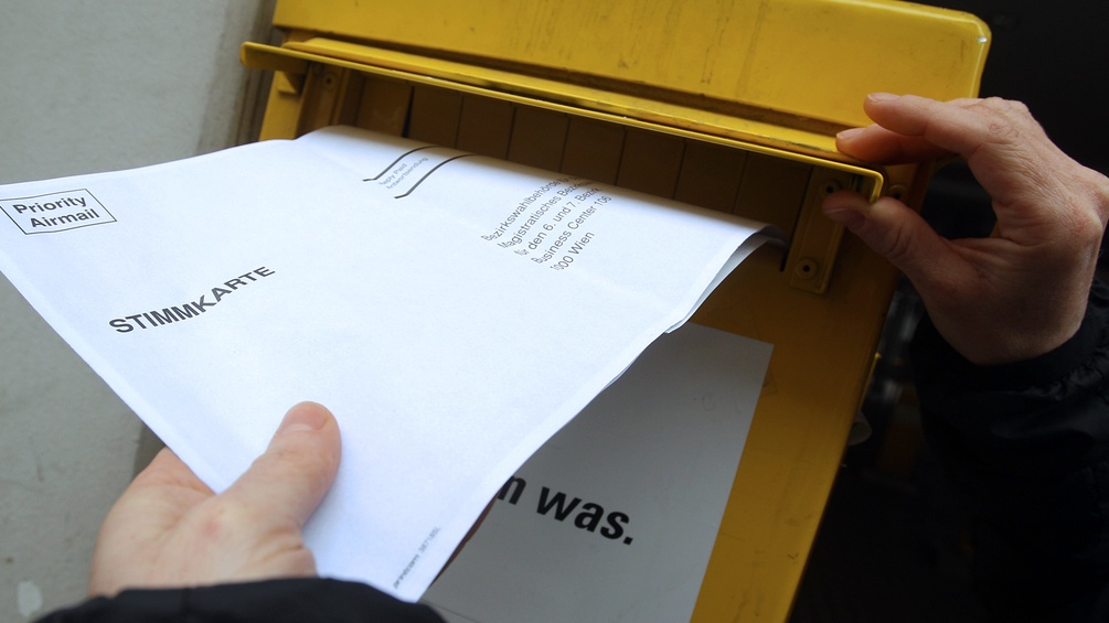 Eine Stimmkarte wird in den Briefkasten geworfen