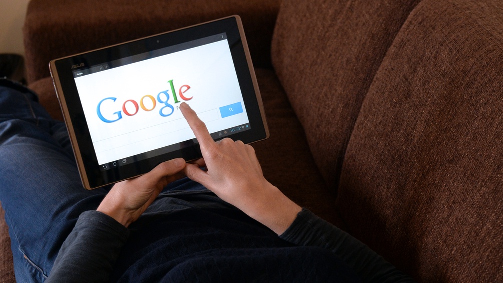 Eine Frau benutzt auf ihrem iPad die Suchmaschiene Google.