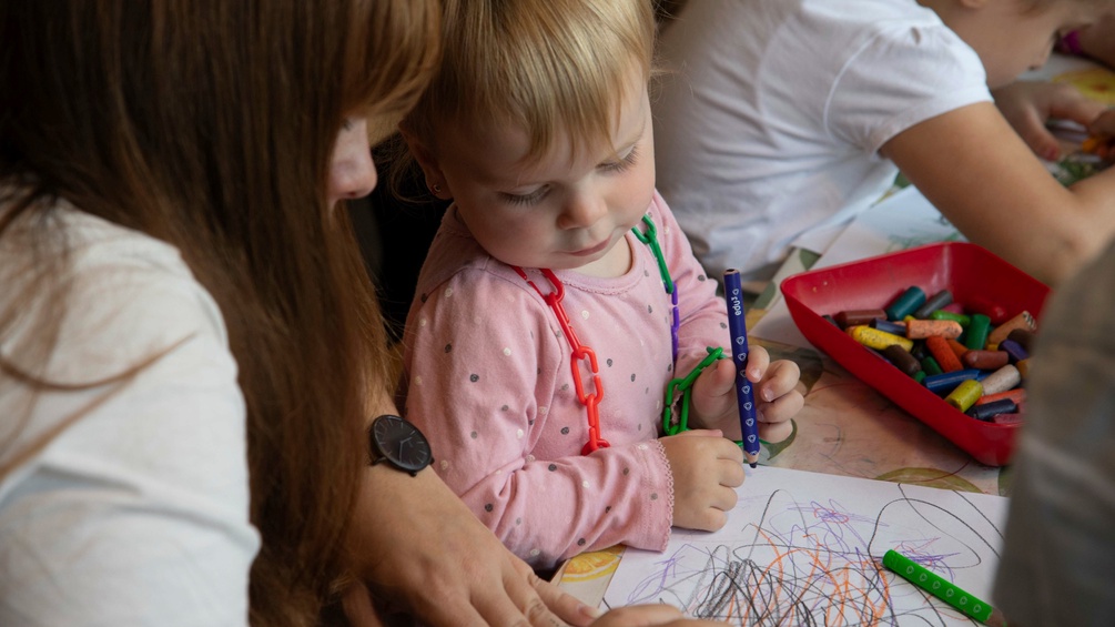 Eine Pädagogin mit Kindergartenkind.