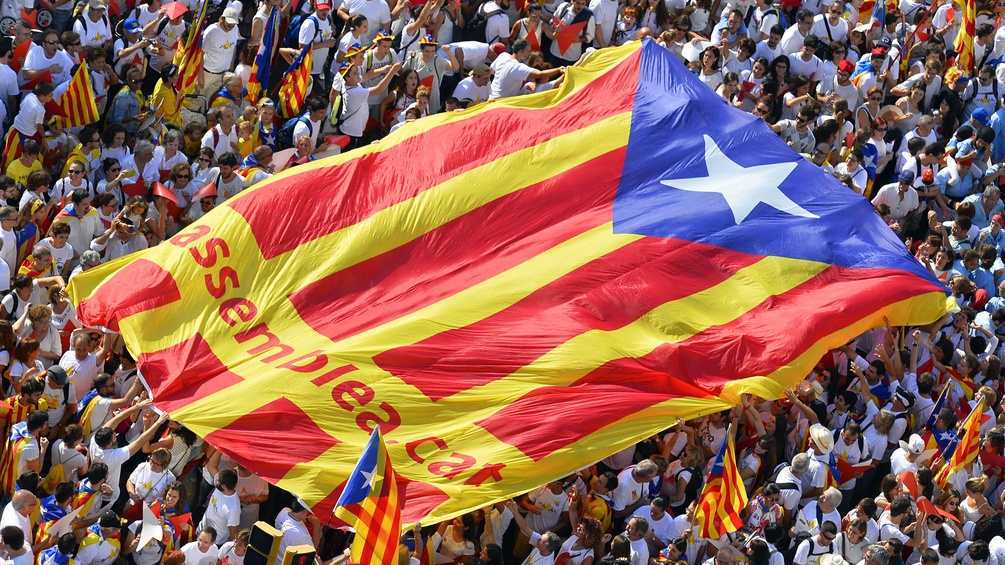 Eine Menschenmenge hält die katalanische Unabhängigkeitsfahne