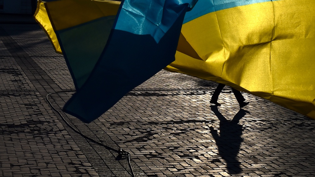 Passant hinter ukrainischer Flagge
