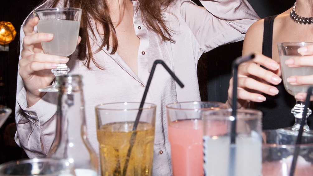 Cocktails, dahinter Frauenoberkörper